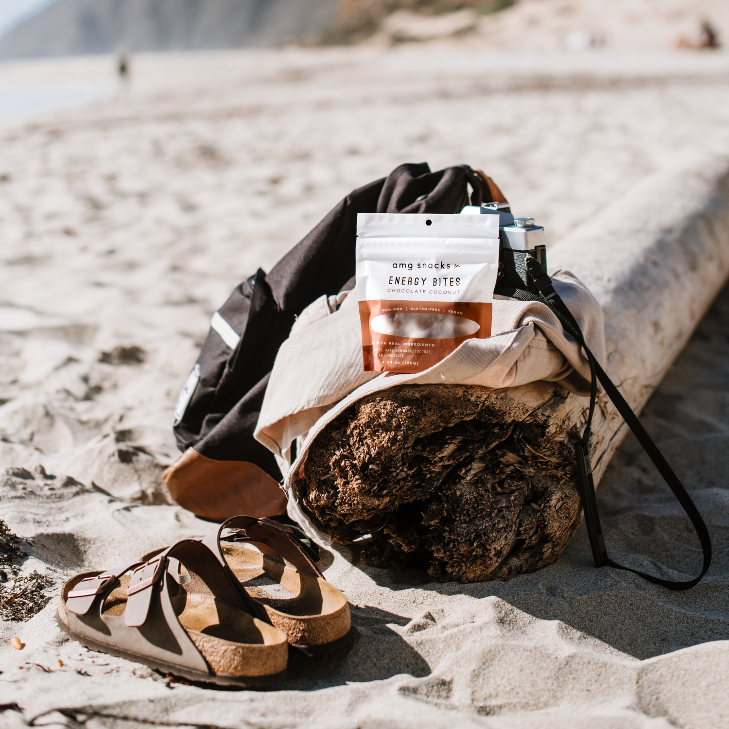 Energy Bites on backpack, atop beach driftwood.