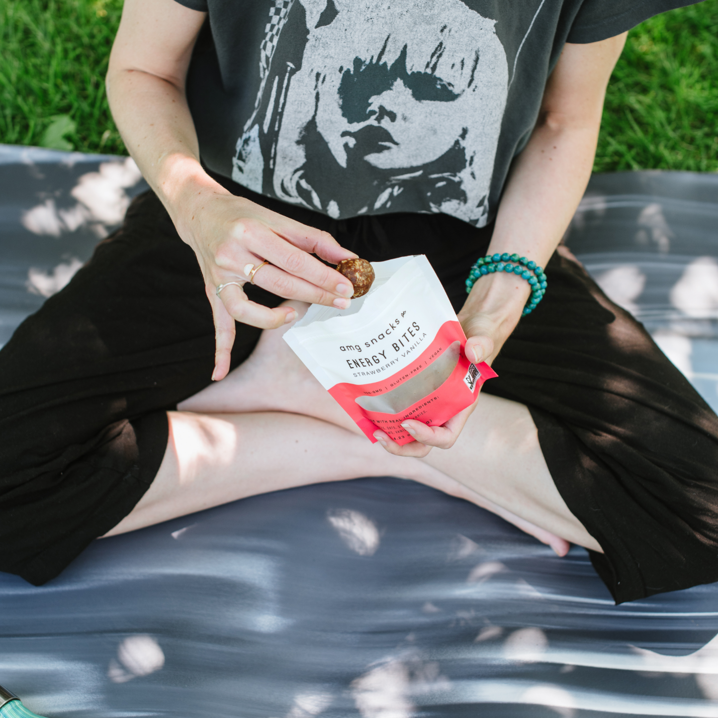 Person on ground taking energy bite from bag.