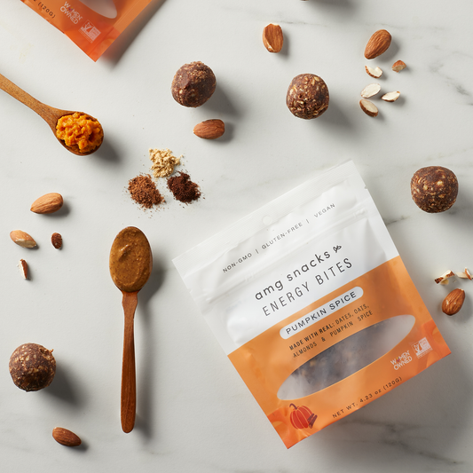 Pumpkin Spice Energy Bites, with almonds, and pumpkin puree on marble background.