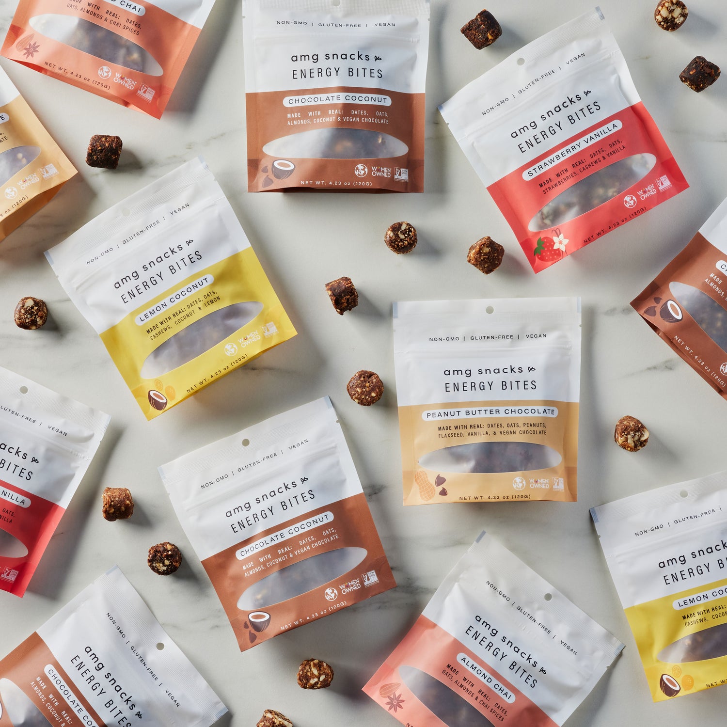 Variety of snack bags and energy bites on a white surface